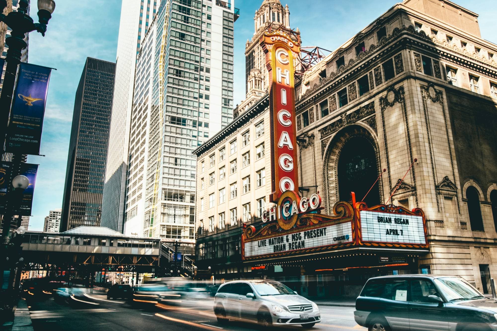 The Chicago Theatre sign over a busy street, with cars blurred by motion